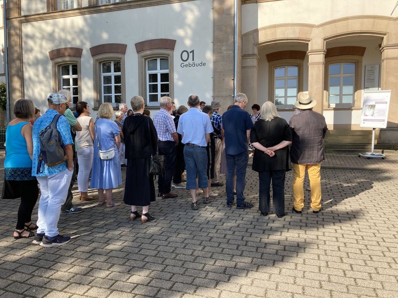 Eine Gruppe von Menschen steht bei der Gedenkveranstaltung 2023 an der Stolperschwelle.